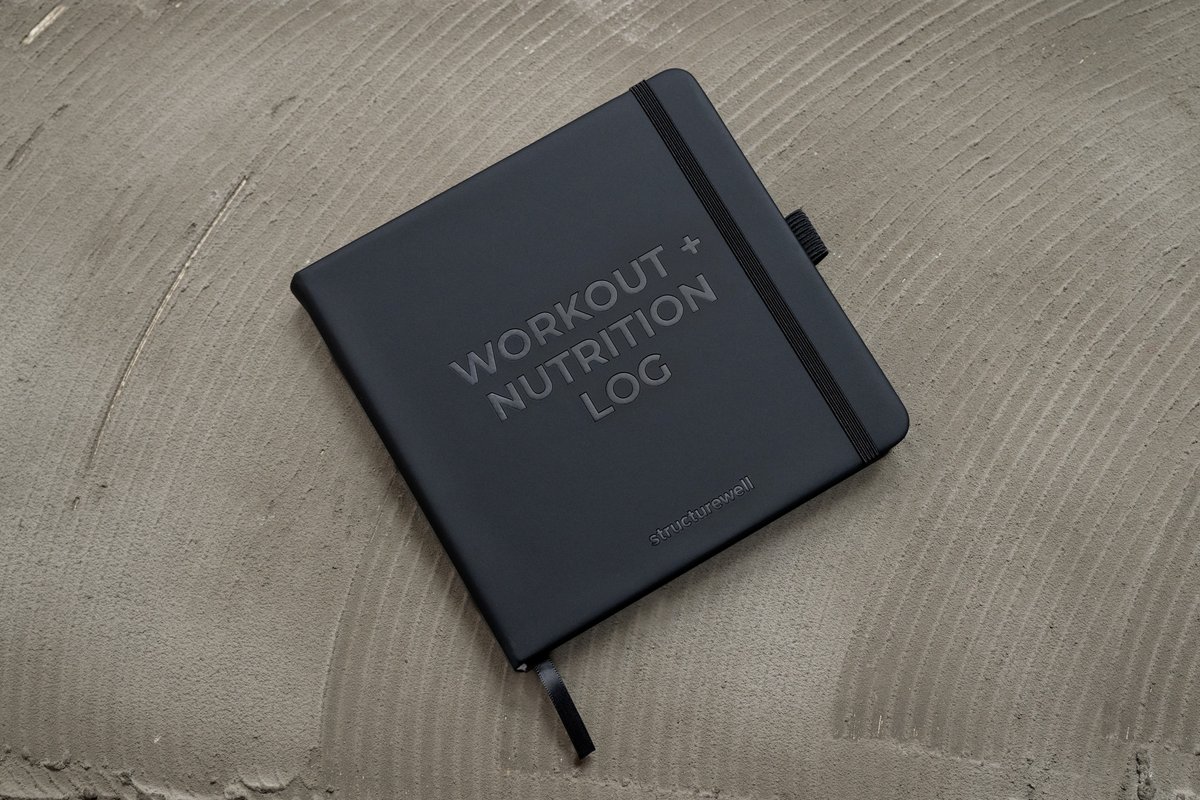 Structurewell Workout + Nutrition Log on concrete surface